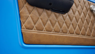 1976 classic ford bronco in blue patina paint with whiskey leather interior door panel detail