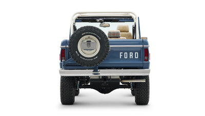 Rear view of Classic Ford Bronco in blue with mounted spare tire and white roll cage