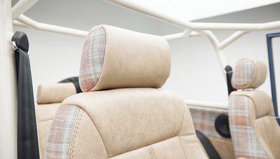 Close-up of tan seat headrest with plaid fabric accents inside vehicle