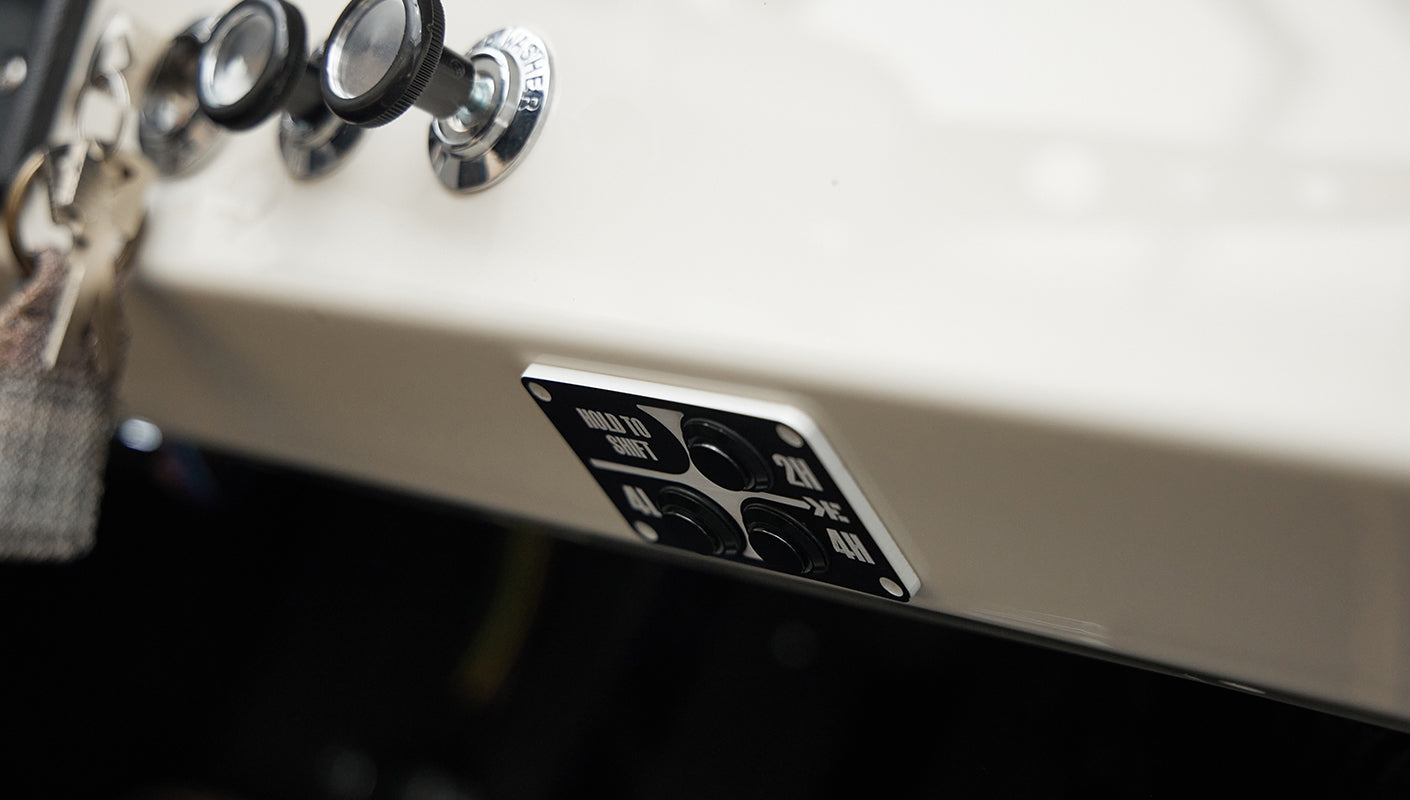 Dashboard control panel with black knobs and switches labeled for 2H, 4L, and 4H drive settings