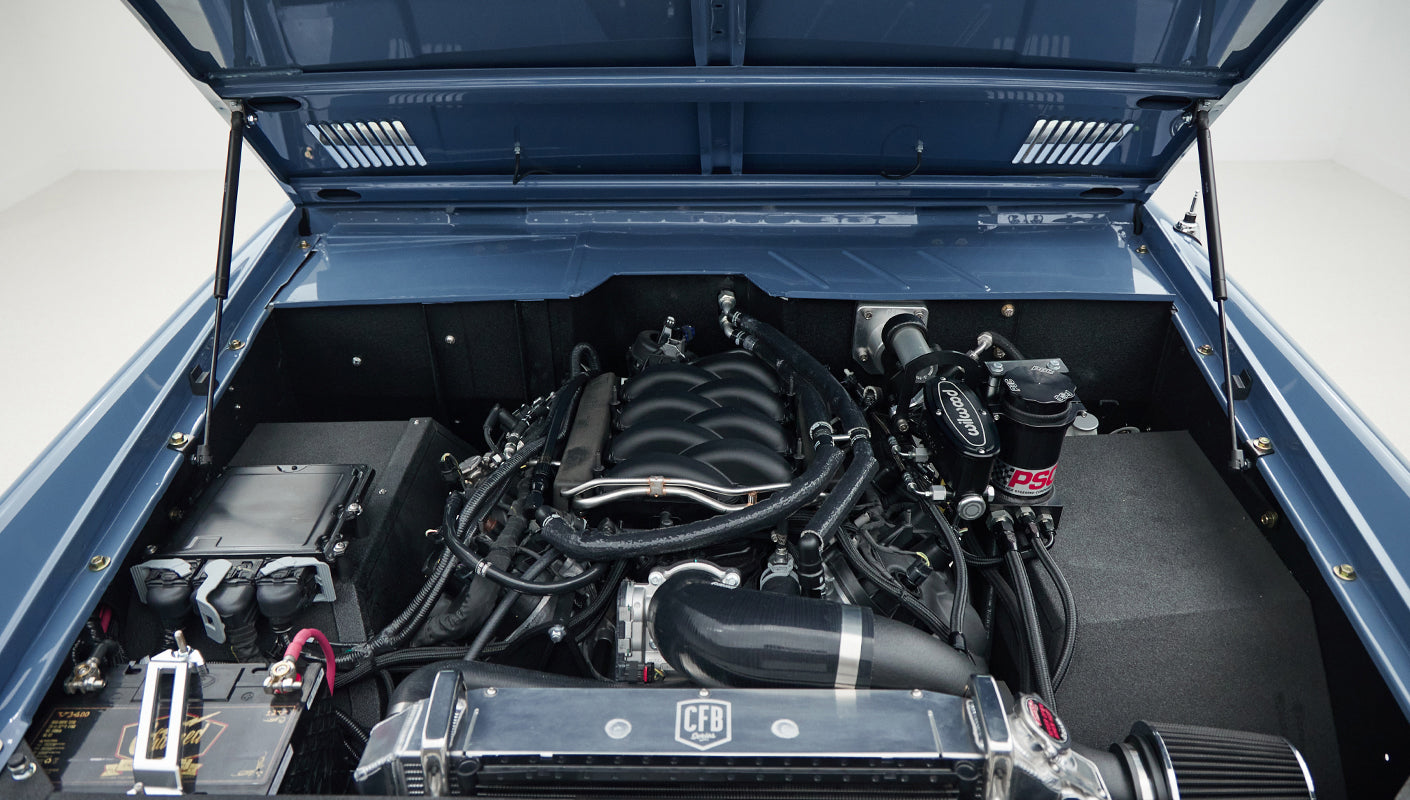 Blue painted engine bay with clean engine, hoses, and radiator visible