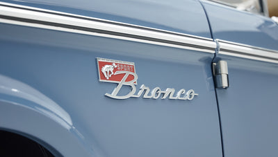Close-up of Classic Ford Bronco red and silver Sport Bronco emblem on blue door panel