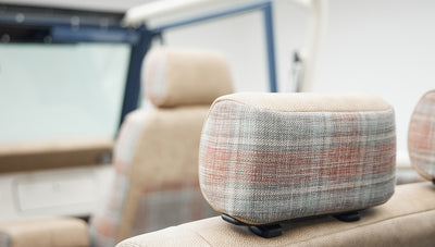 Close-up of beige and plaid fabric upholstery on a Classic Ford Bronco headrest