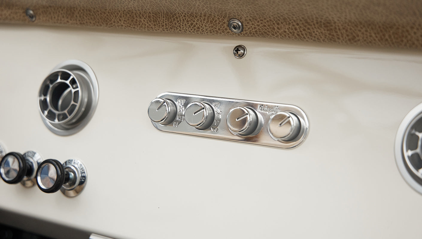 Close-up of Classic Ford Bronco dashboard controls and air vents in silver chrome finish