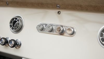 Close-up of Classic Ford Bronco dashboard controls and air vents in silver chrome finish