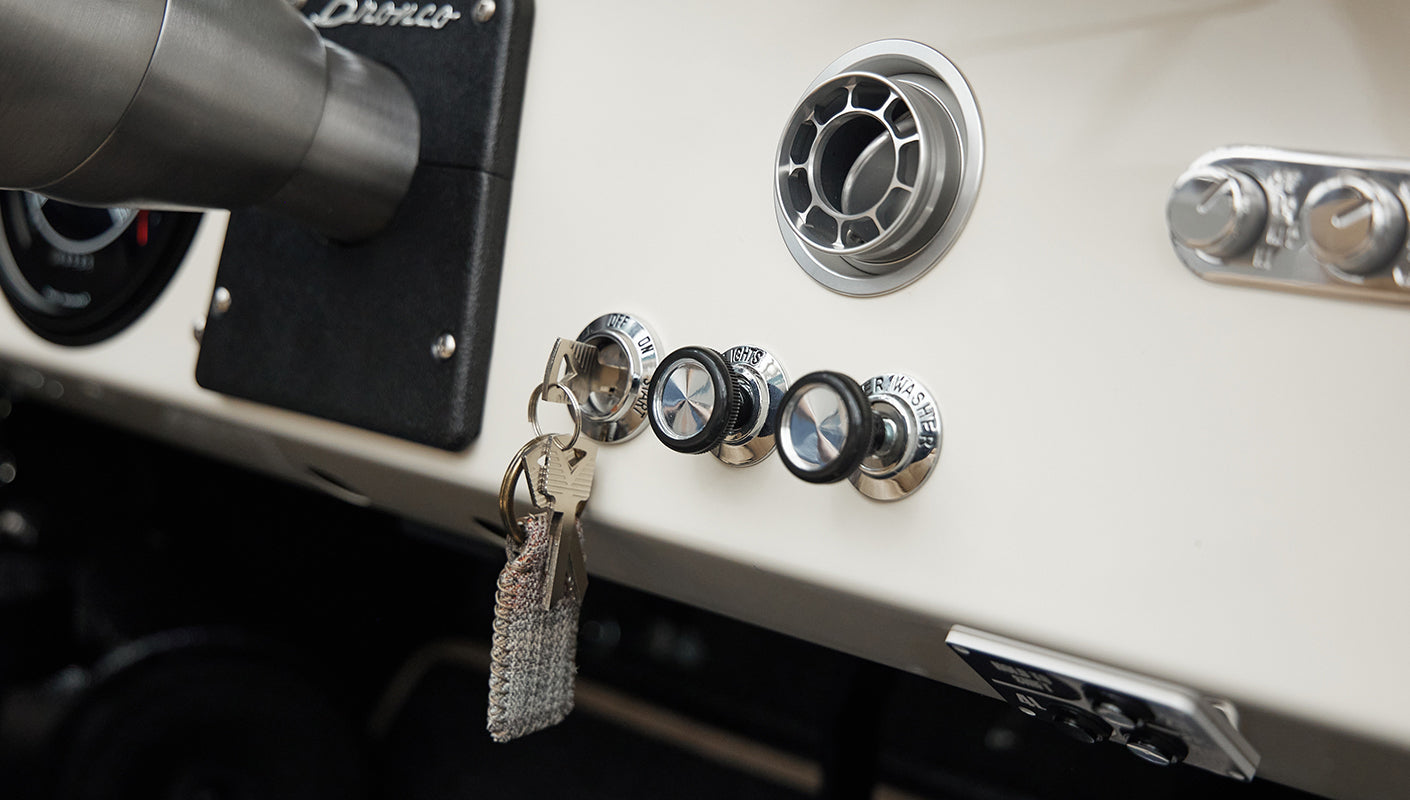 Close-up of Classic Ford Bronco dashboard knobs and ignition key with leather fob