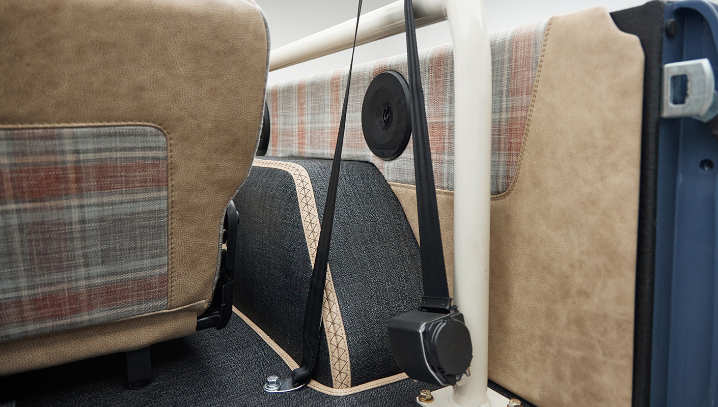 Close-up of speaker and beige plaid upholstery inside Classic Ford Bronco