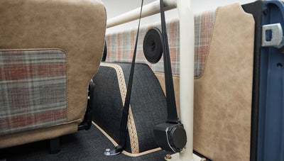 Close-up of speaker and beige plaid upholstery inside Classic Ford Bronco