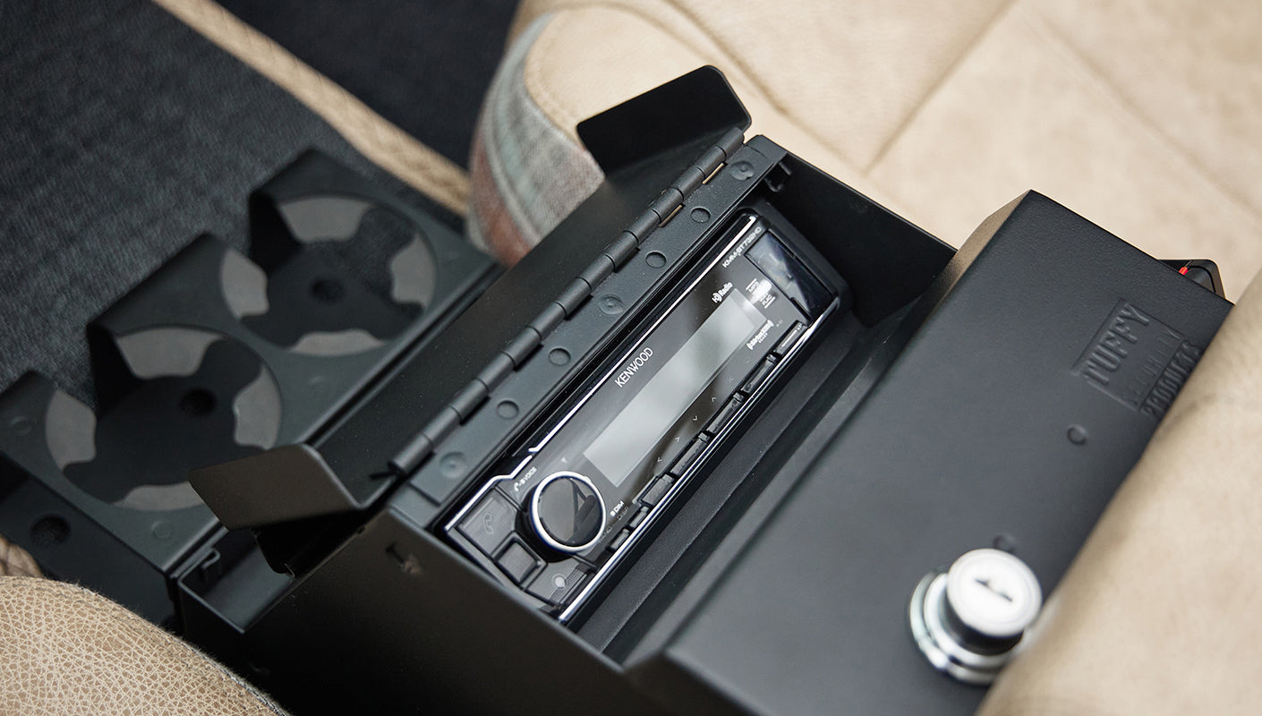 Open center console compartment with Kenwood stereo system and cup holders in tan interior