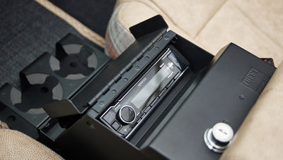 Open center console compartment with Kenwood stereo system and cup holders in tan interior