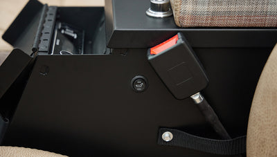 Black control knob and seatbelt buckle next to tan seat in vehicle interior