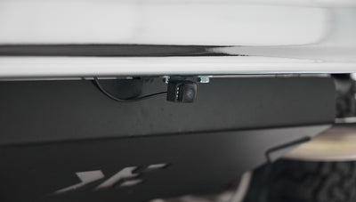 Close-up of a backup camera mounted beneath the rear bumper of the Classic Ford Bronco