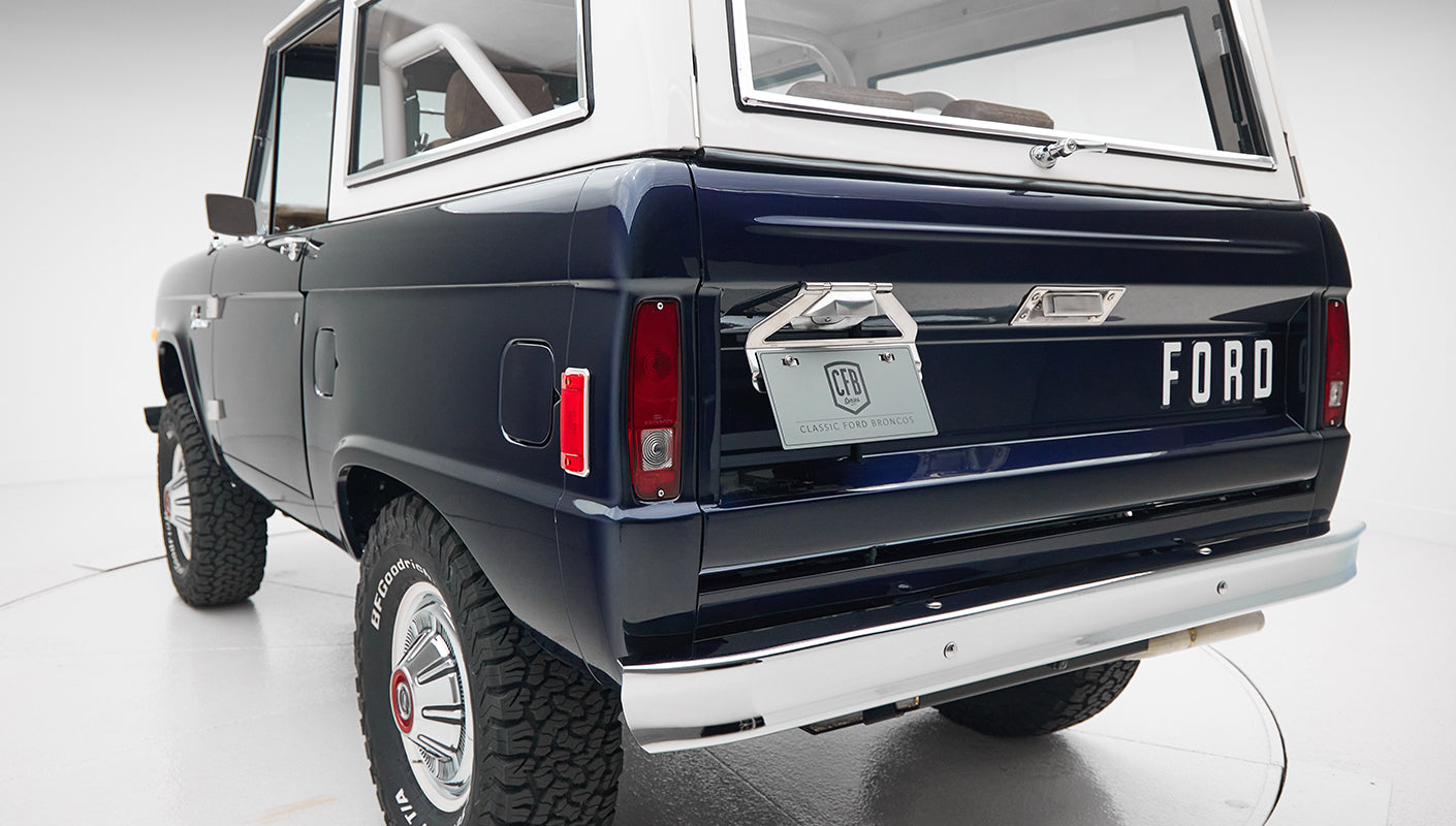 Three-quarter rear view of Classic Ford Bronco showing sapphire blue paint, white roof, and license plate