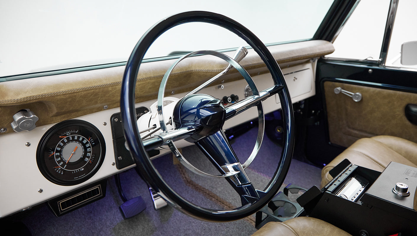 Close-up of Classic Ford Bronco steering wheel and dashboard with tan leather seats