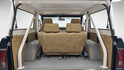Rear interior of Classic Ford Bronco showing tan seats and roll cage