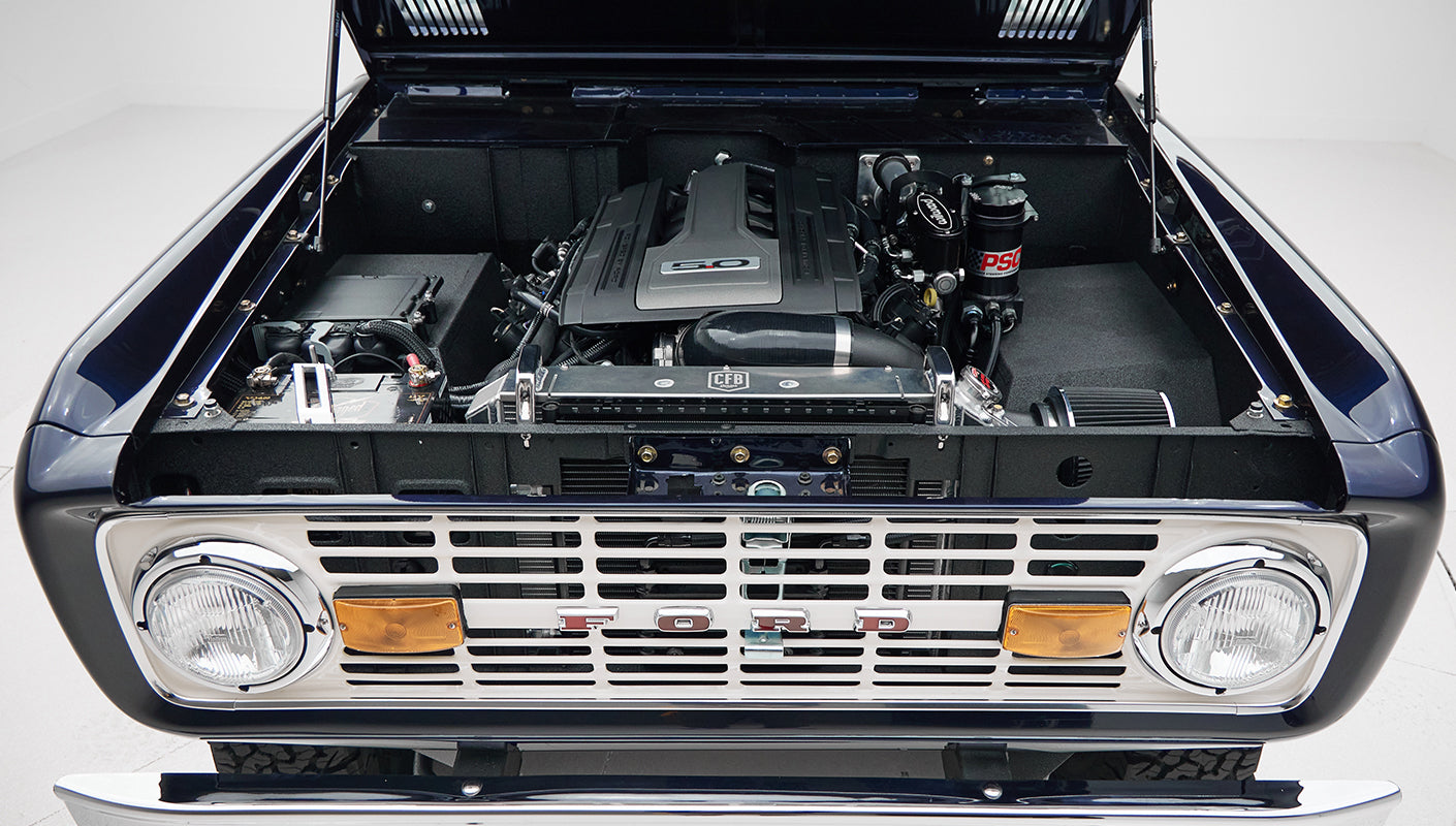 Front view of Classic Ford Bronco with hood open, showing engine and front grille with headlights
