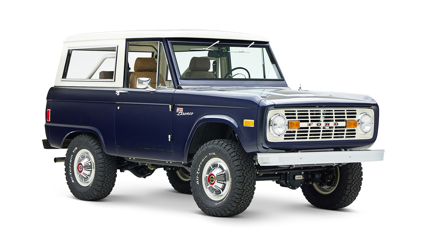 Classic Ford Bronco in sapphire blue with white roof, angled left front view