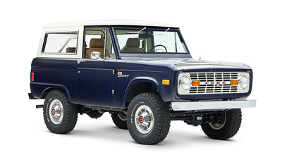 Classic Ford Bronco in sapphire blue with white roof, angled left front view