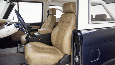 Interior of classic Ford Bronco showing tan leather seats and part of steering wheel