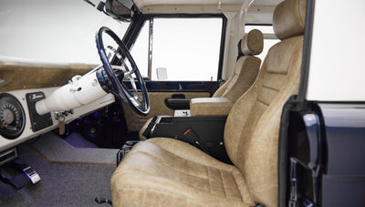 Interior front seats and steering wheel view showing tan leather upholstery and white dashboard