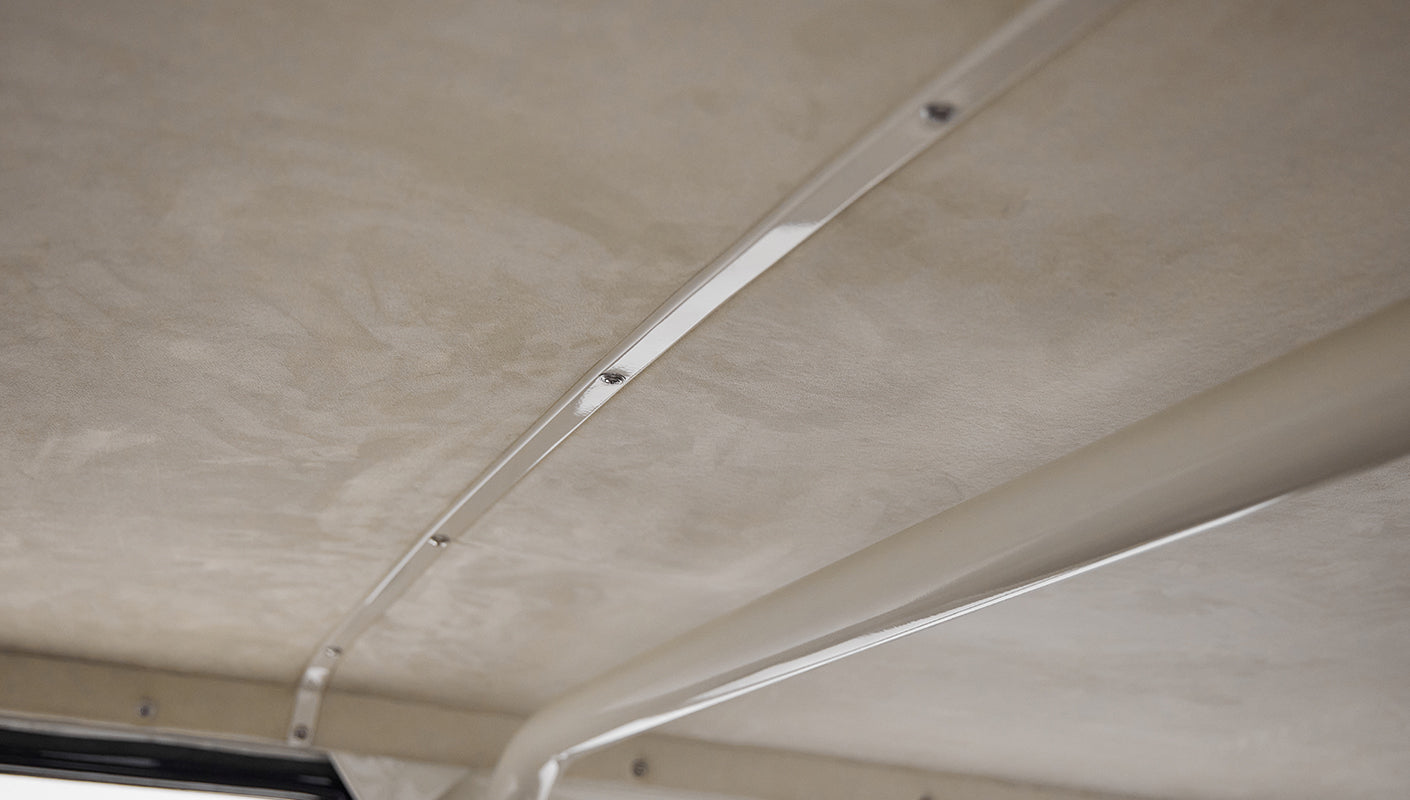 Close-up of tan roof lining with metal ribbing inside Classic Ford Bronco