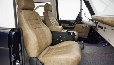 Interior front seats of Classic Ford Bronco with tan leather upholstery and black center console