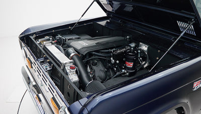 Classic Ford Bronco engine bay with raised hood in sapphire blue color