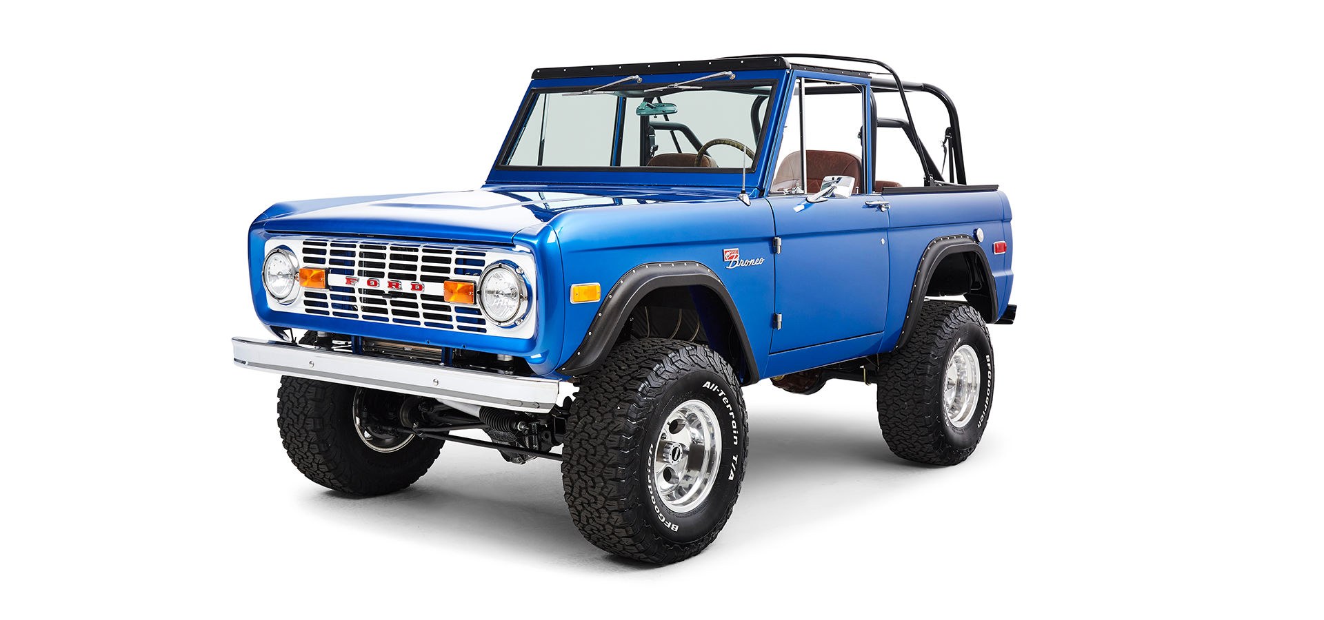 Front driver angle view of blue Classic Ford Bronco showing grille, headlights, and side mirror