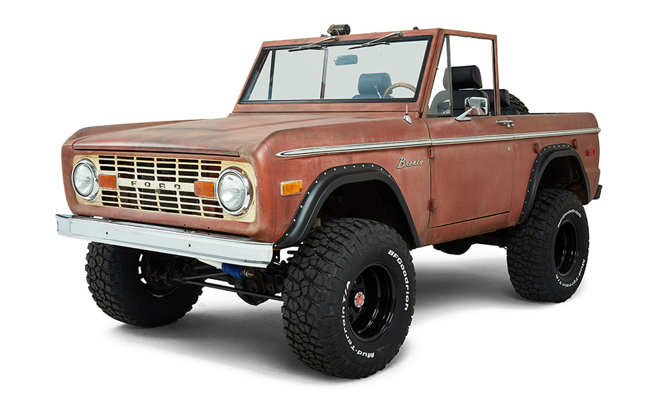 Front driver angle view of a red Classic Ford Bronco with lift suspension and black wheels