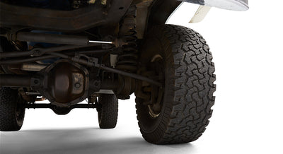 Close-up of front driver suspension and tire on a green Classic Ford Bronco