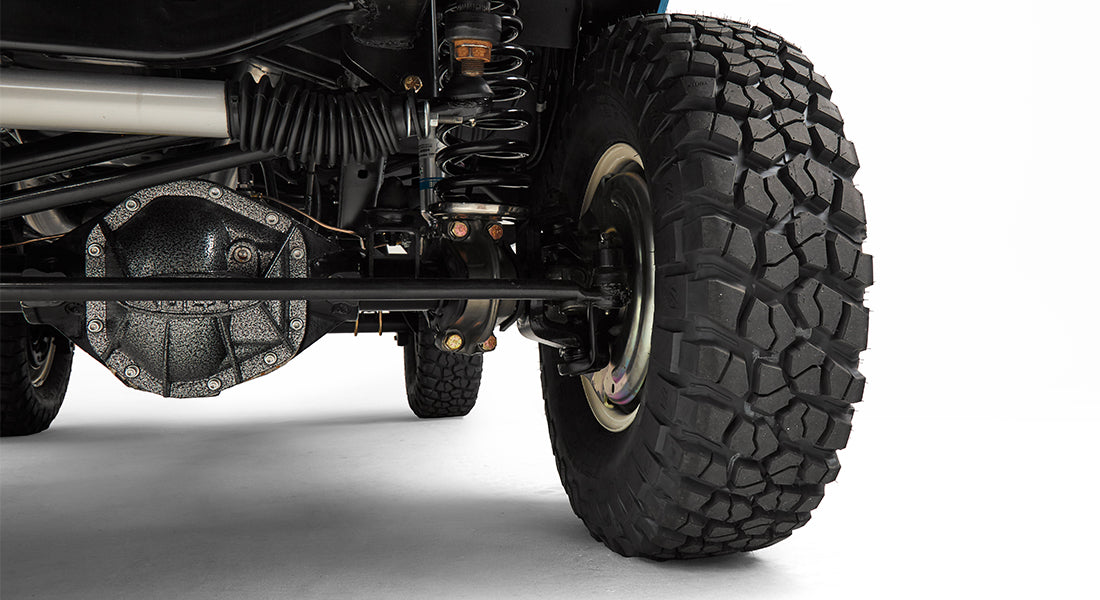 Close-up of rear axle, suspension, and large off-road tire of a Classic Ford Bronco