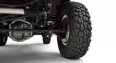 Close-up of rear axle, suspension, and large off-road tire of a Classic Ford Bronco