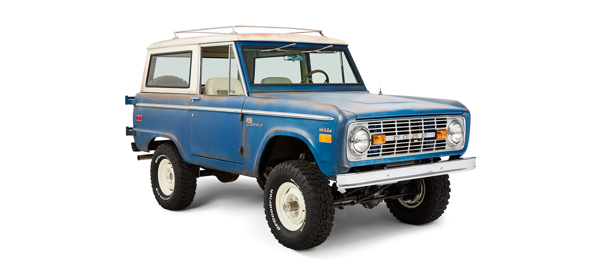 Classic Ford Bronco front passenger side angled view with white roof and off-road tires