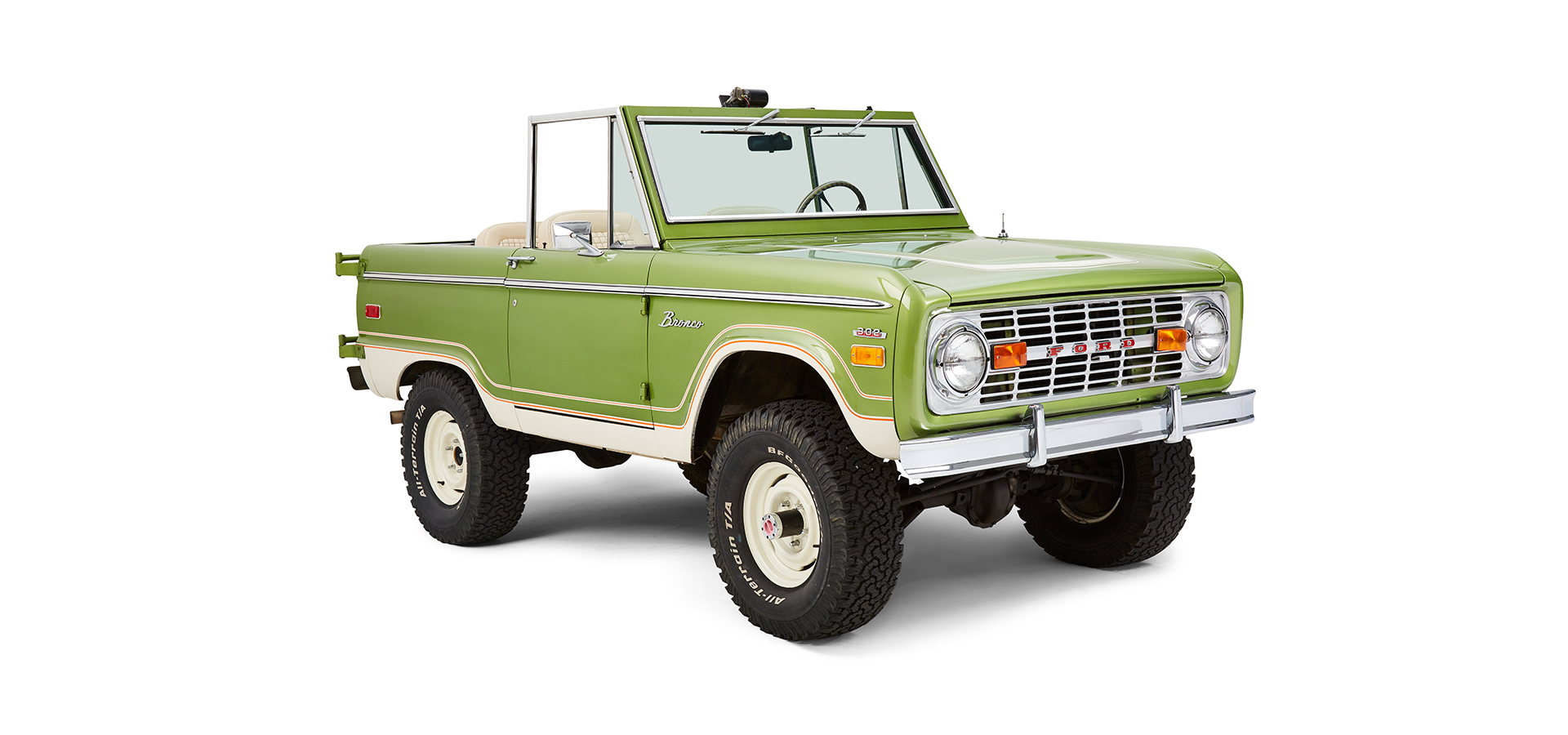 Front passenger angle of green Classic Ford Bronco with open roof and off-road tires
