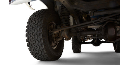 Close-up of front passenger suspension and tire on a green Classic Ford Bronco