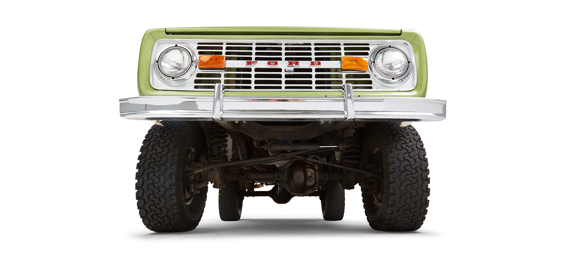 Close-up undercarriage view of green Classic Ford Bronco front axle and suspension