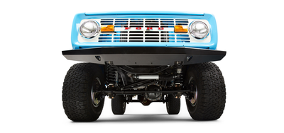 Front underside view of blue Classic Ford Bronco showing suspension, axle, and off-road tires.