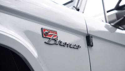 Side emblem of Classic Ford Bronco with red and black sport badge on gray body