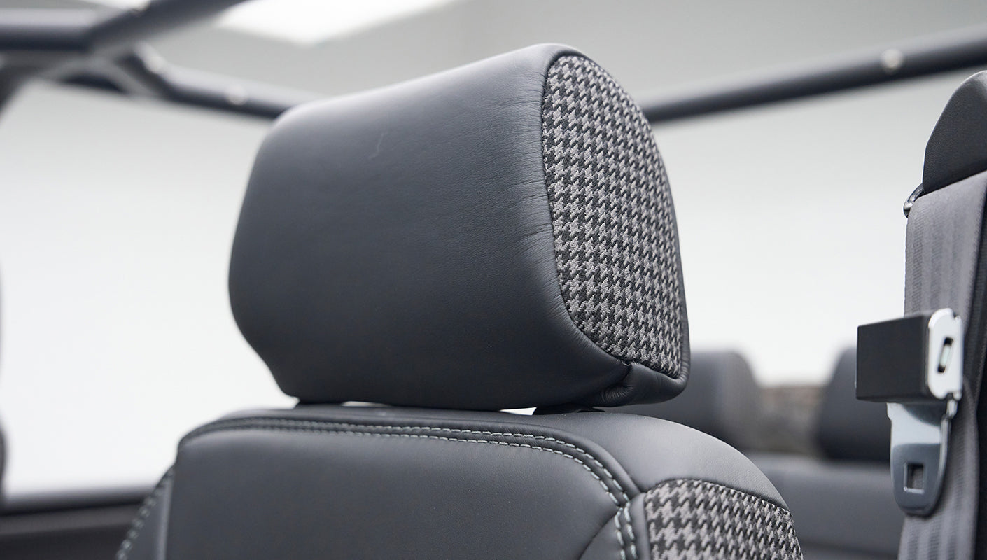 Headrest with black leather and gray houndstooth pattern on Classic Ford Bronco front seat