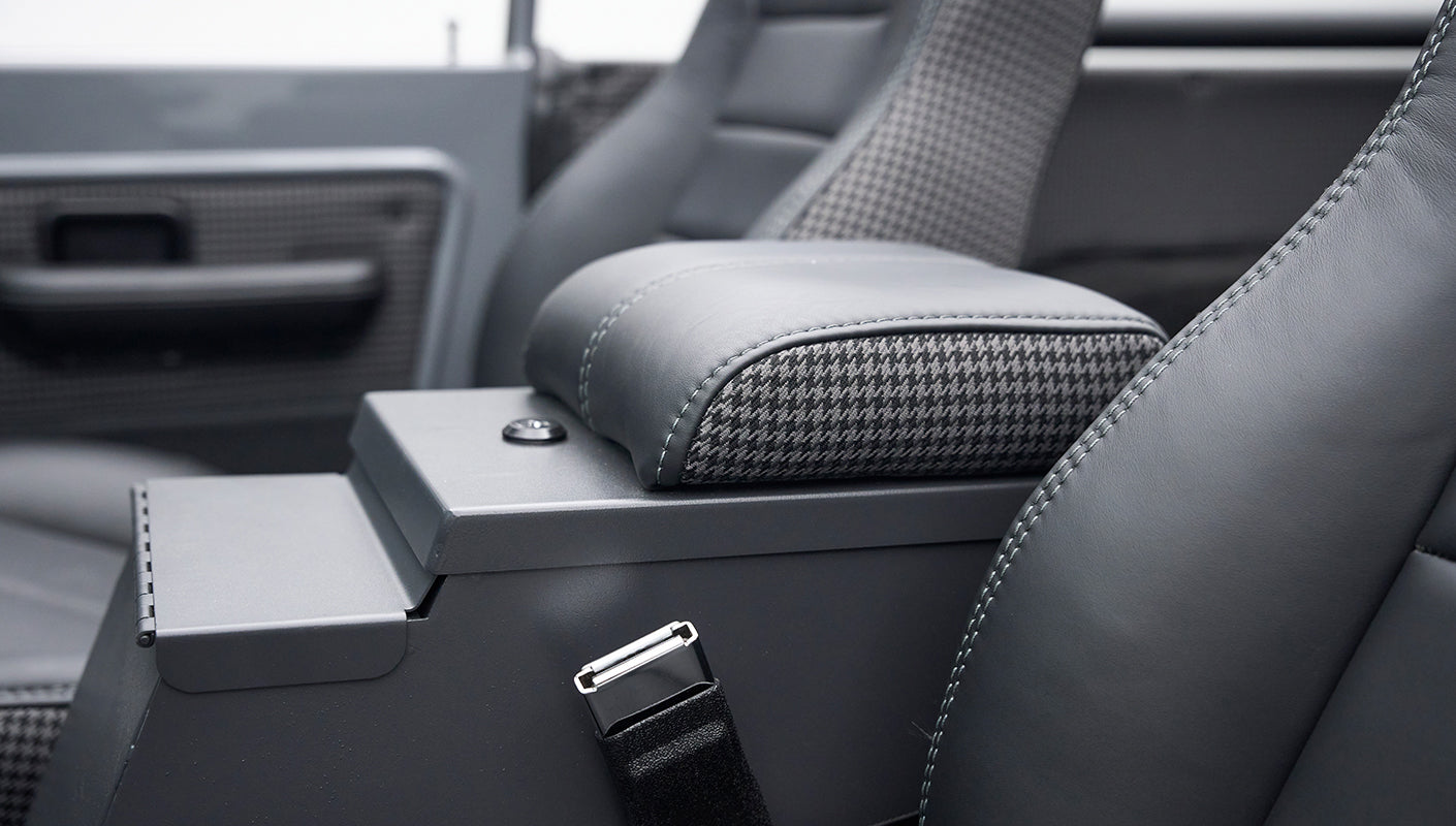 Armrest and seatbelt buckle between the front seats in Classic Ford Bronco interior