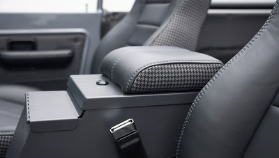 Armrest and seatbelt buckle between the front seats in Classic Ford Bronco interior