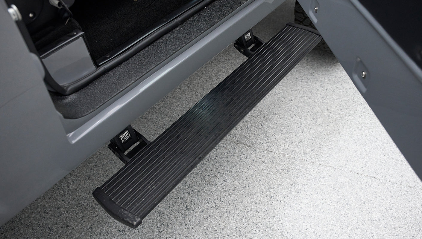 Black electric running board extended from gray vehicle door