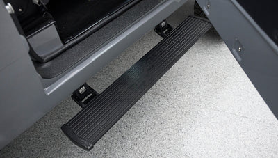 Black electric running board extended from gray vehicle door
