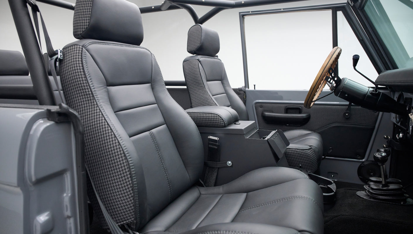 Classic Ford Bronco interior with gray and black houndstooth seats and wooden steering wheel