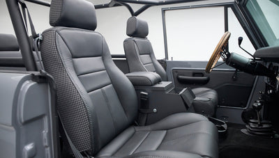 Classic Ford Bronco interior with gray and black houndstooth seats and wooden steering wheel