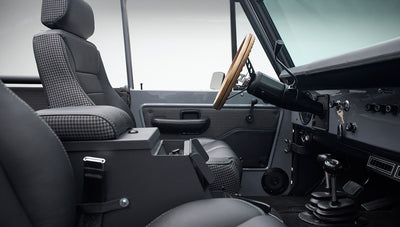 Driver side view of Classic Ford Bronco interior showing seats, steering wheel, gear shift