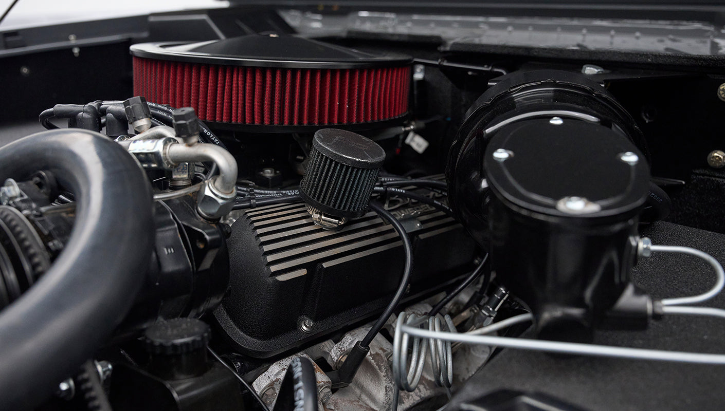 Close-up of engine components and air filter inside Classic Ford Bronco engine bay