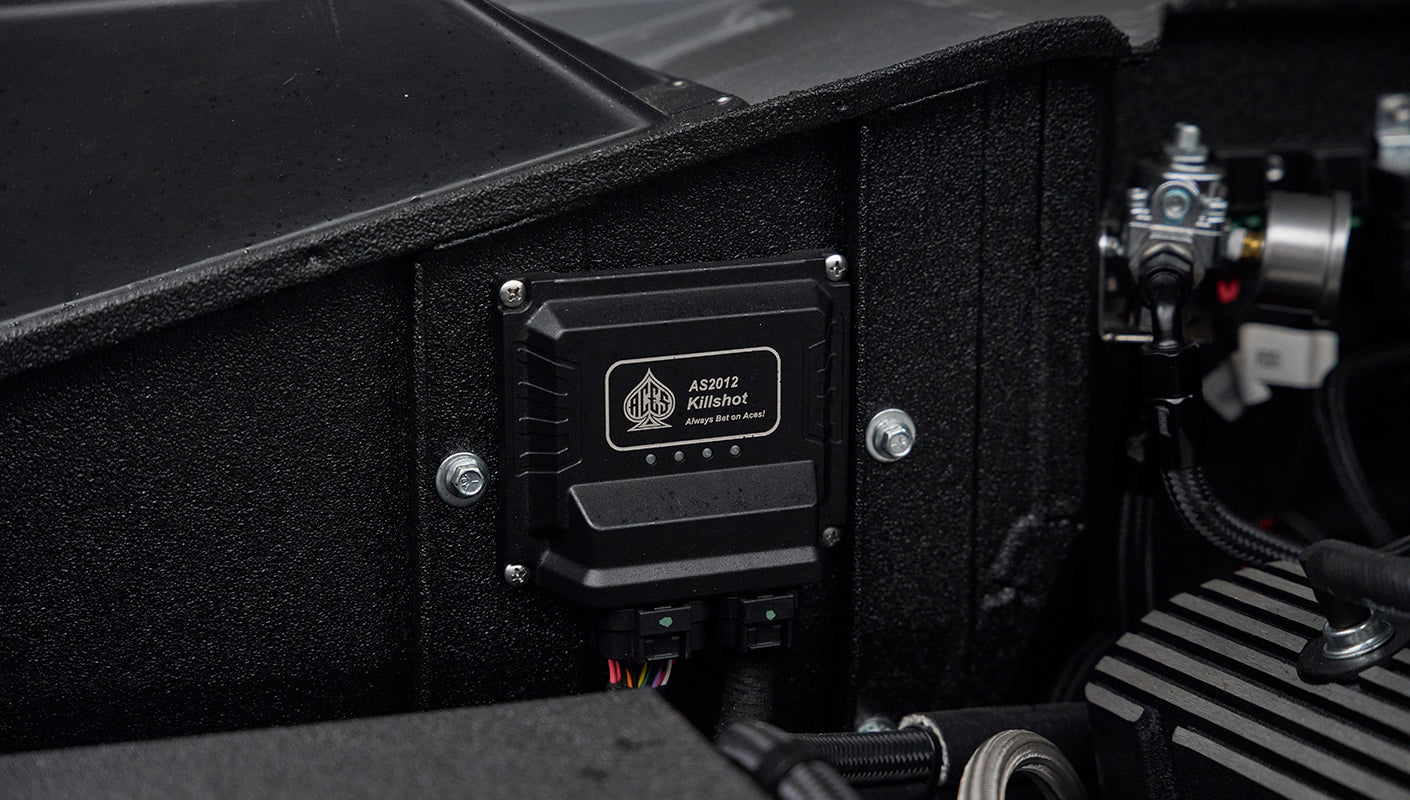Black AS2012 Killshot automotive component mounted on textured black panel with wiring.