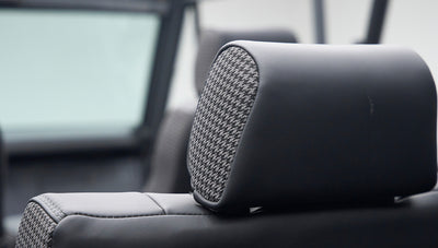Close-up of Classic Ford Bronco interior black headrest with gray houndstooth fabric insert.