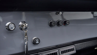 Gray dashboard with ignition key inserted, air vents, control knobs, and wiper washer knob in Classic Ford Bronco
